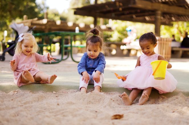 Children playing outdoors in sand 